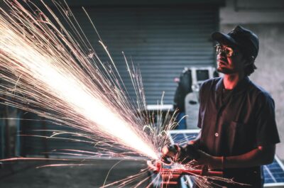 Man in brown shirt grinding metal